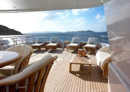 a deck with chairs and a body of water in the background aboard HARLE Yacht for Sale