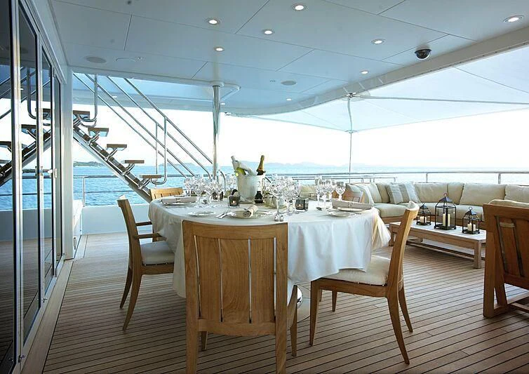 a dining table with chairs and a view of the water aboard HARLE Yacht for Sale
