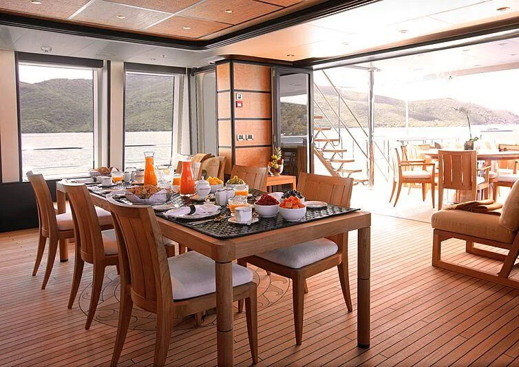 a dining table with chairs and a view of the ocean aboard HARLE Yacht for Sale