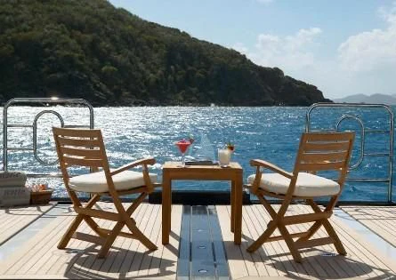 a table and chairs on a deck overlooking a body of water aboard HARLE Yacht for Sale