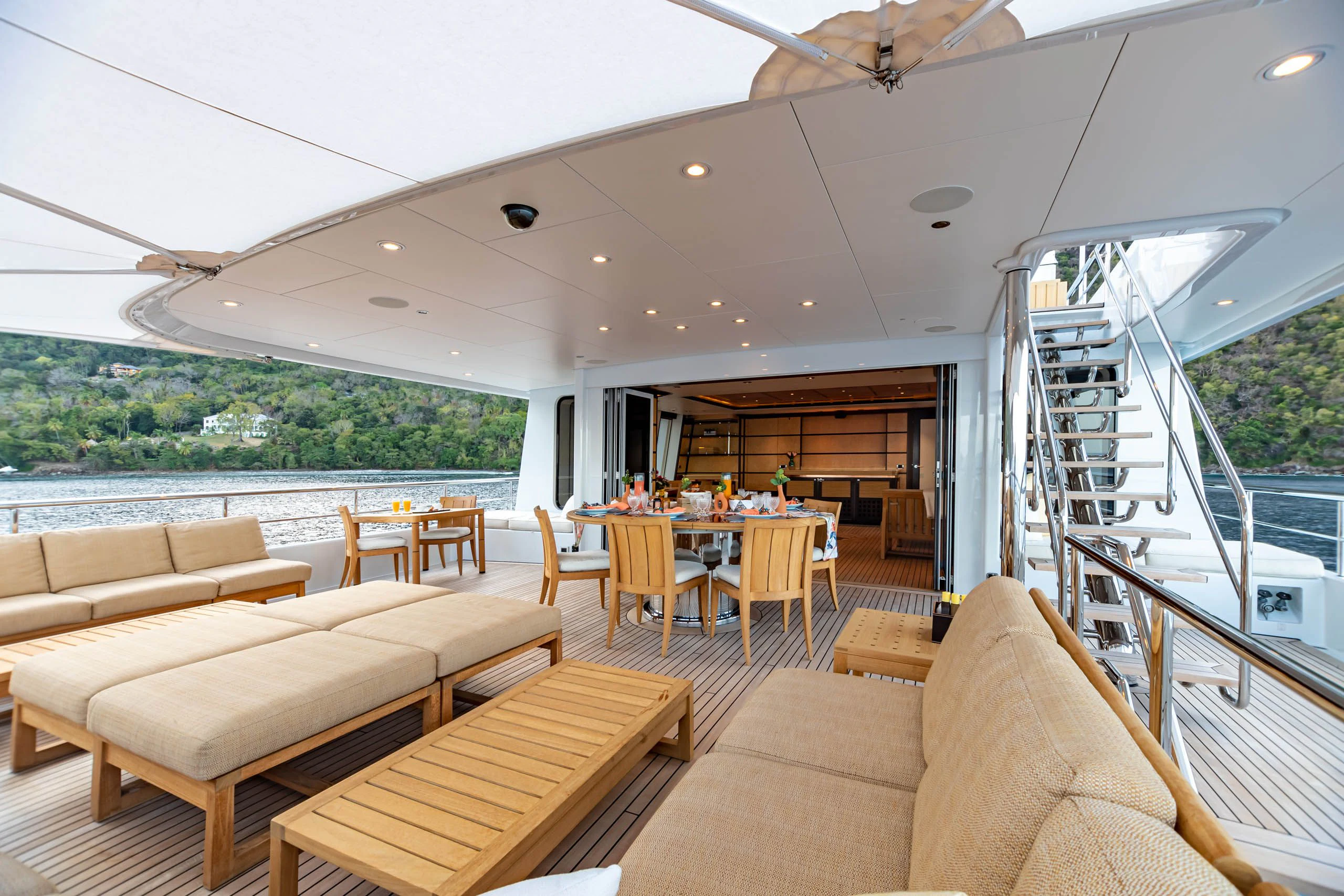a living room with a staircase and a glass door leading to a balcony aboard HARLE Yacht for Sale
