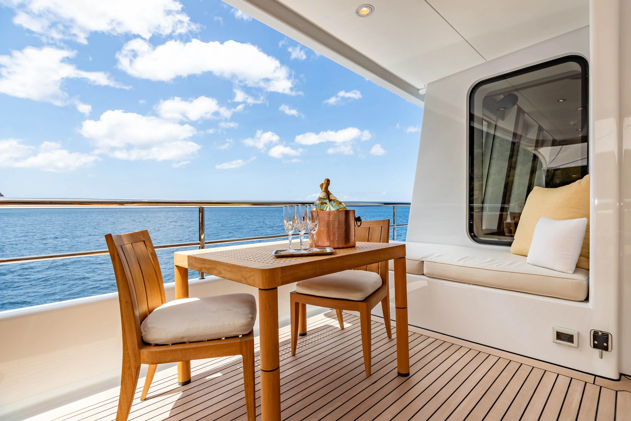 a table and chairs on a deck overlooking the ocean aboard HARLE Yacht for Sale