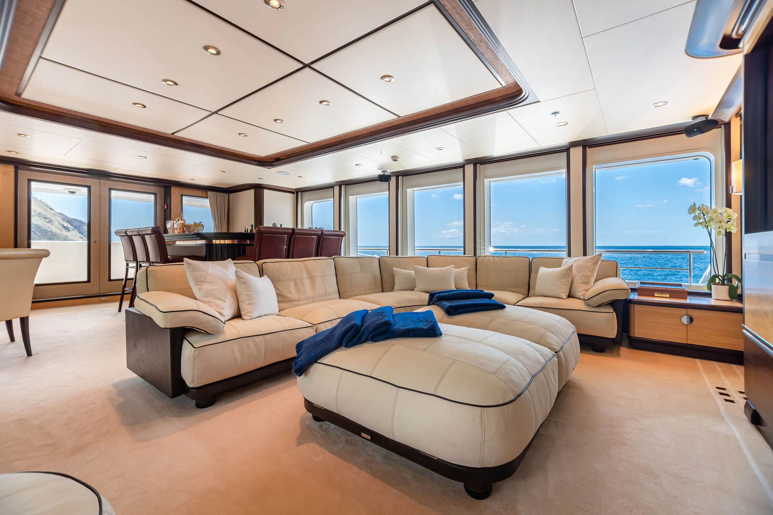 a large living room with a large blue couch aboard HARLE Yacht for Sale