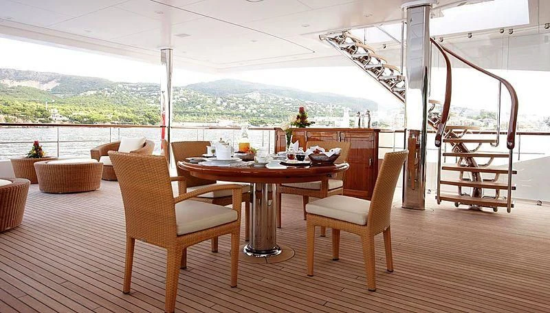 a table and chairs on a patio aboard LADY CHRISTINE Yacht for Sale