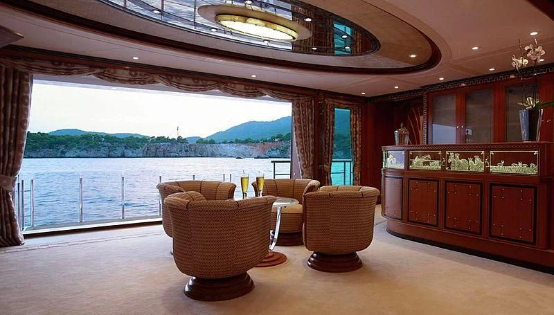 a room with a large window and a wood cabinet with chairs and a large window aboard LADY CHRISTINE Yacht for Sale