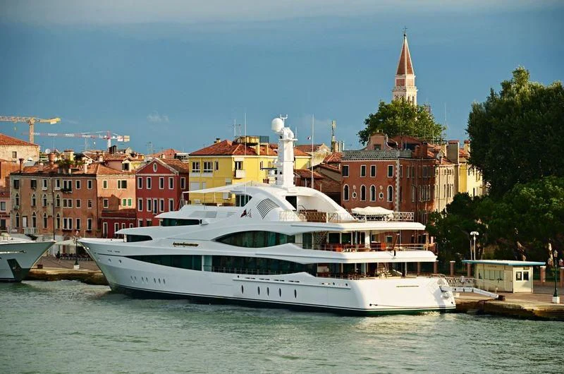 a large white boat in a harbor aboard LADY CHRISTINE Yacht for Sale