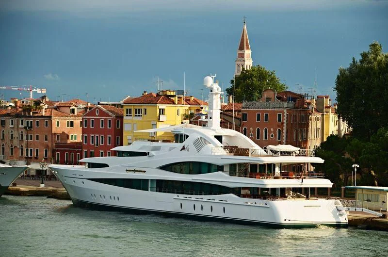 a large white boat in a harbor aboard LADY CHRISTINE Yacht for Sale