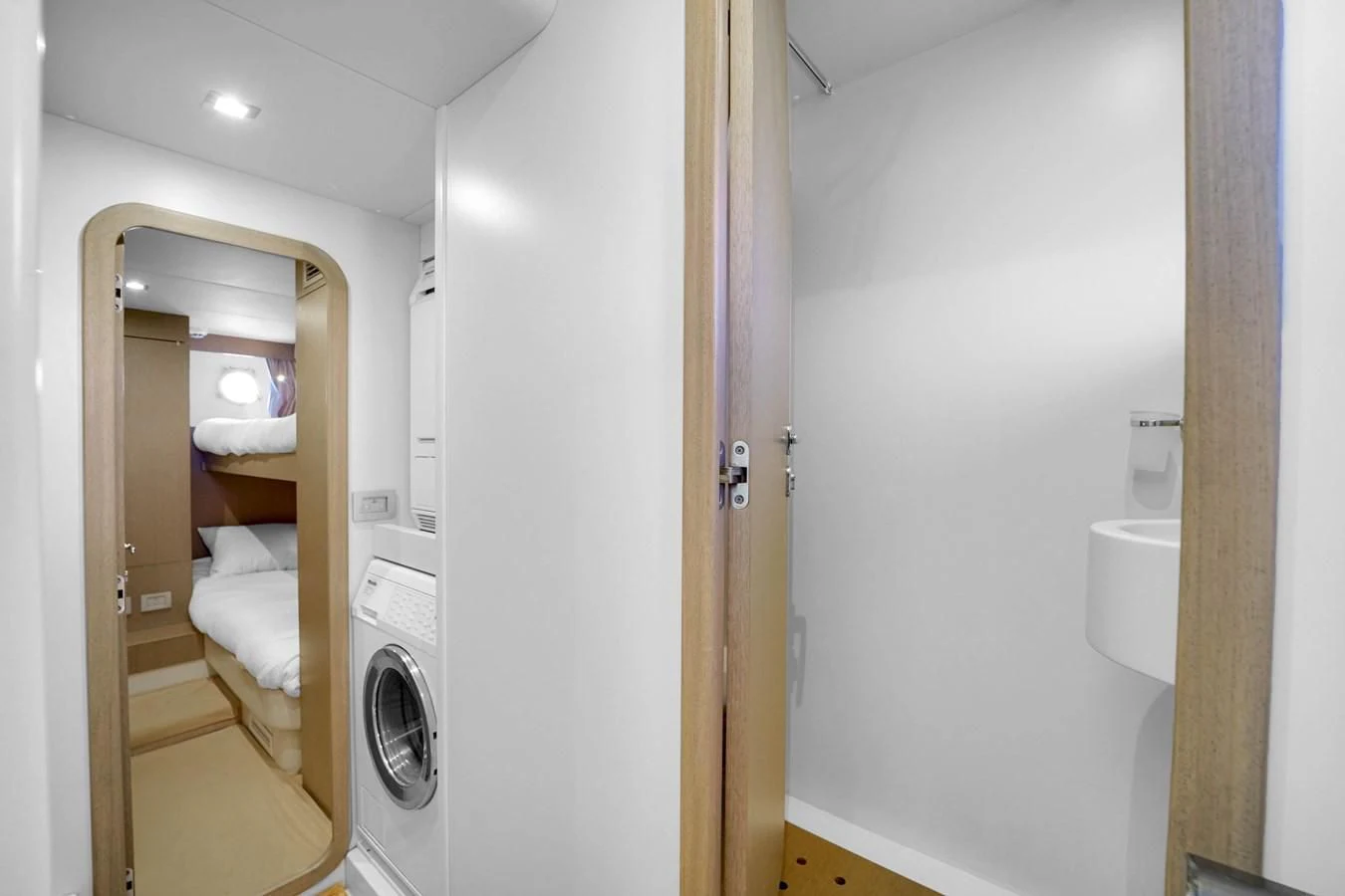 a white bathroom with a wood door aboard KATARIINA XO Yacht for Sale