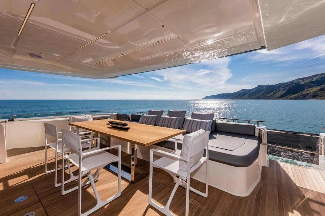 a table and chairs on a deck overlooking a large body of water aboard KATARIINA XO Yacht for Sale