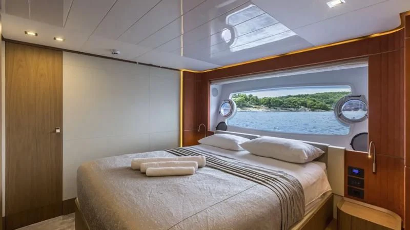 a room with a bed and a window aboard KATARIINA XO Yacht for Sale