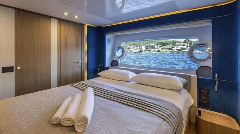 a bed with a large window aboard KATARIINA XO Yacht for Sale
