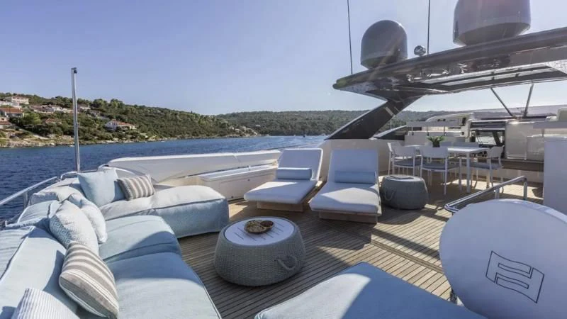 a deck with a pool and a deck with chairs and a boat on it aboard KATARIINA XO Yacht for Sale