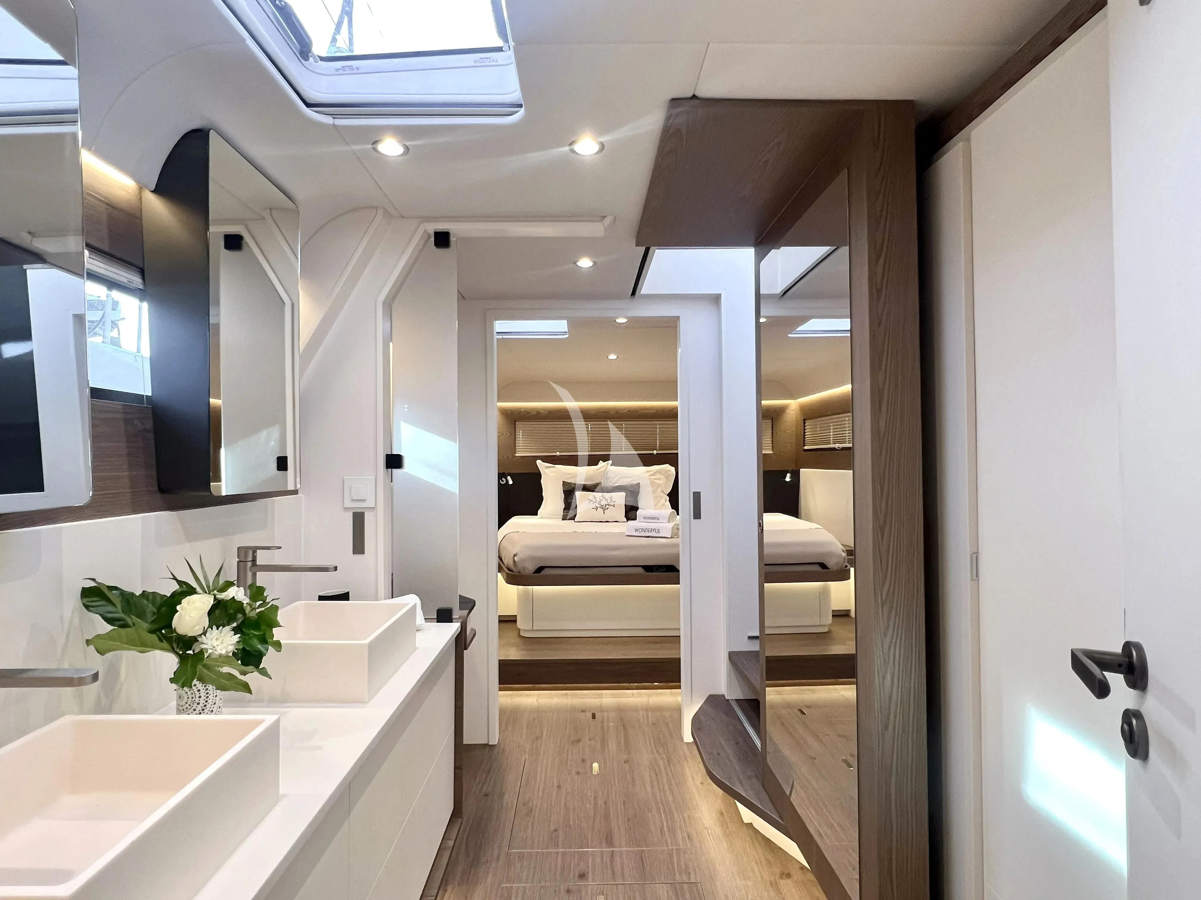a modern looking room with a white bed and a white table aboard WONDERFUL Yacht for Charter