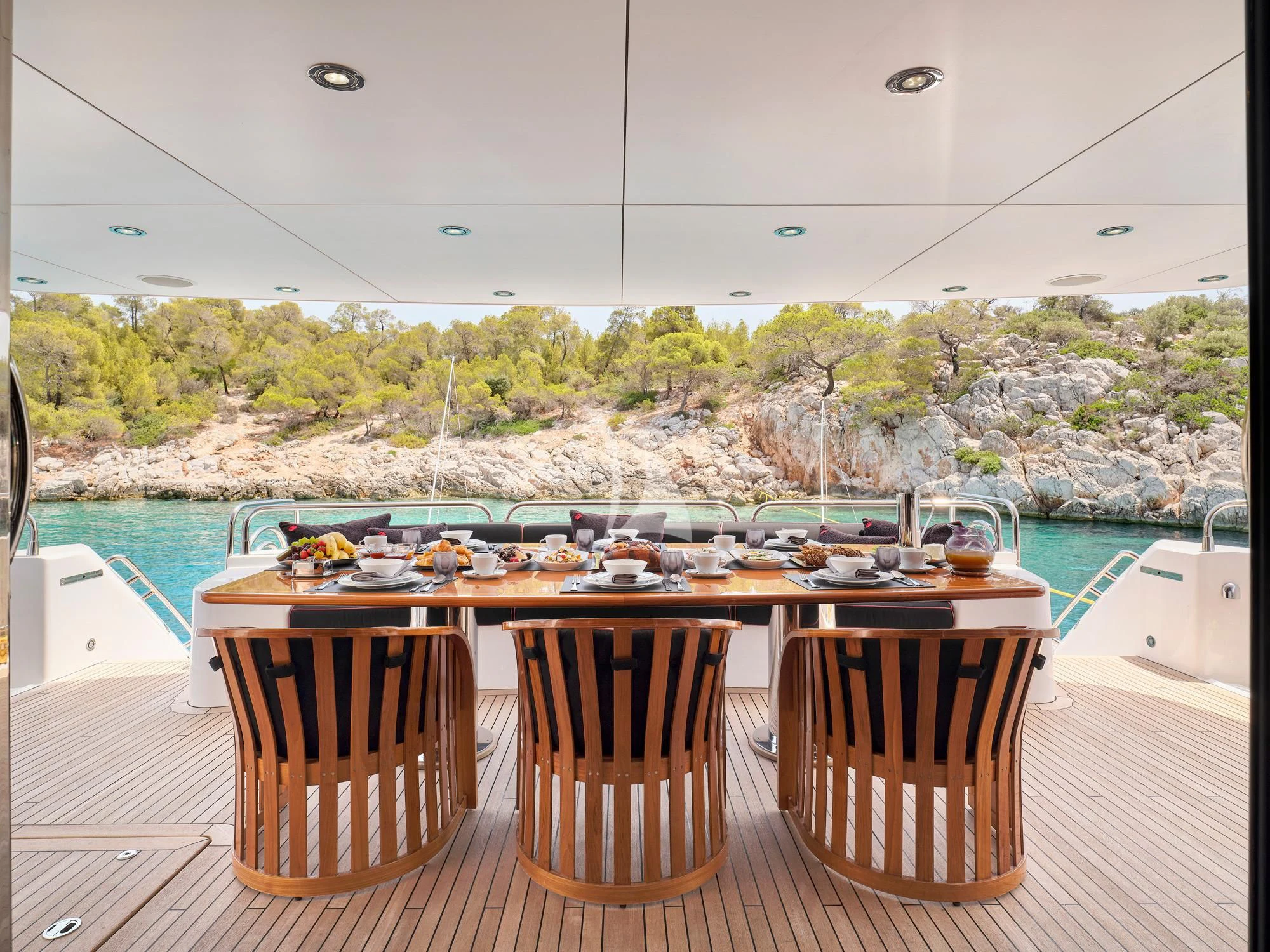 a table with chairs and a view of a city from a balcony aboard WHITE PEARL I Yacht for Sale