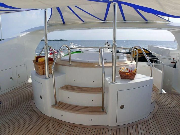 a white boat with a blue canopy aboard HAPPY LIFE Yacht for Sale