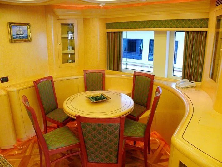 a dining table and chairs in a room with a window aboard HAPPY LIFE Yacht for Sale