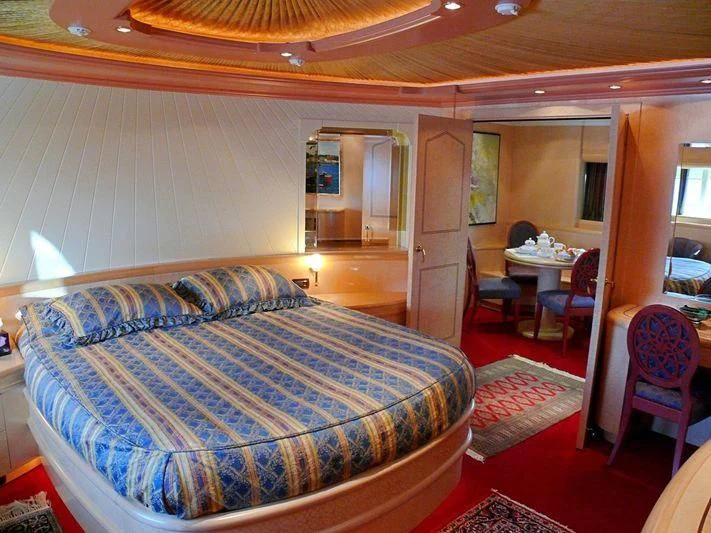a bedroom with a bed and chairs aboard HAPPY LIFE Yacht for Sale