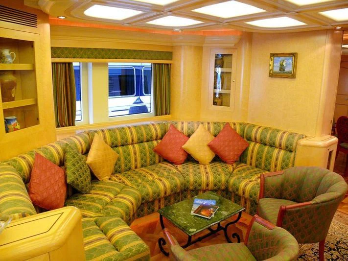 a living room with a green couch aboard HAPPY LIFE Yacht for Sale