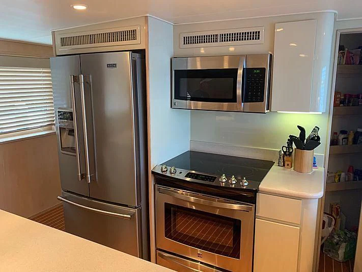 a kitchen with a stainless steel refrigerator aboard LADY GRAY Yacht for Sale