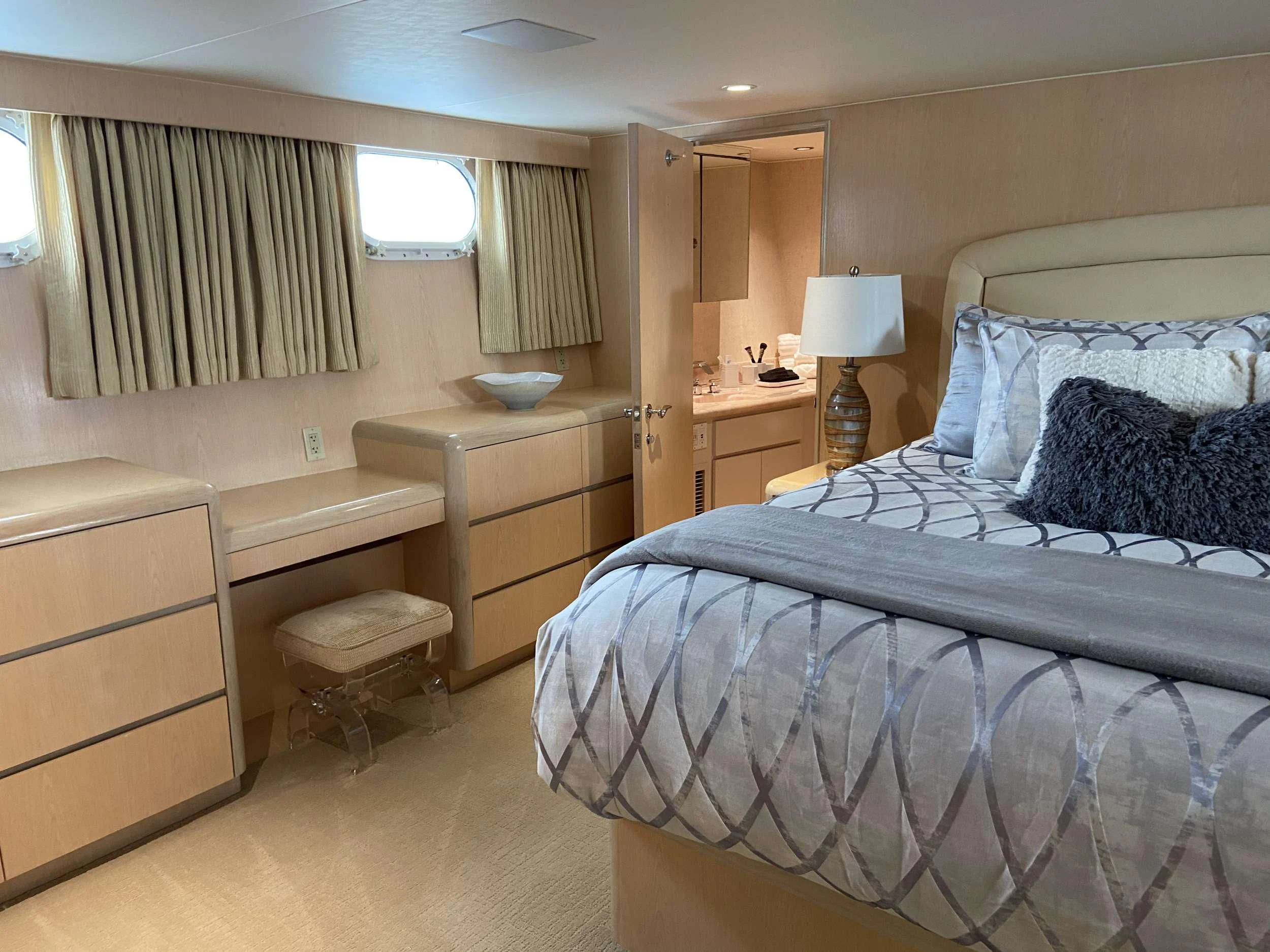 a bedroom with a bed and a dresser aboard LADY GRAY Yacht for Sale