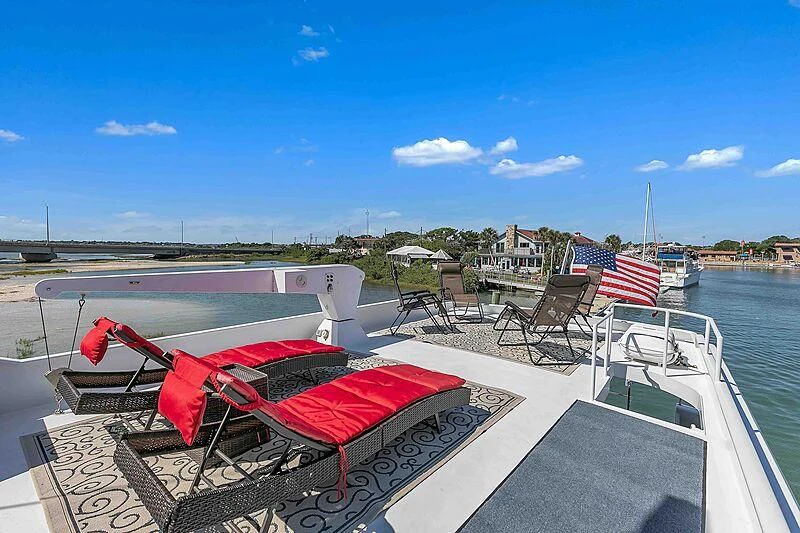 a deck with chairs and tables on it aboard LA VIDA Yacht for Sale