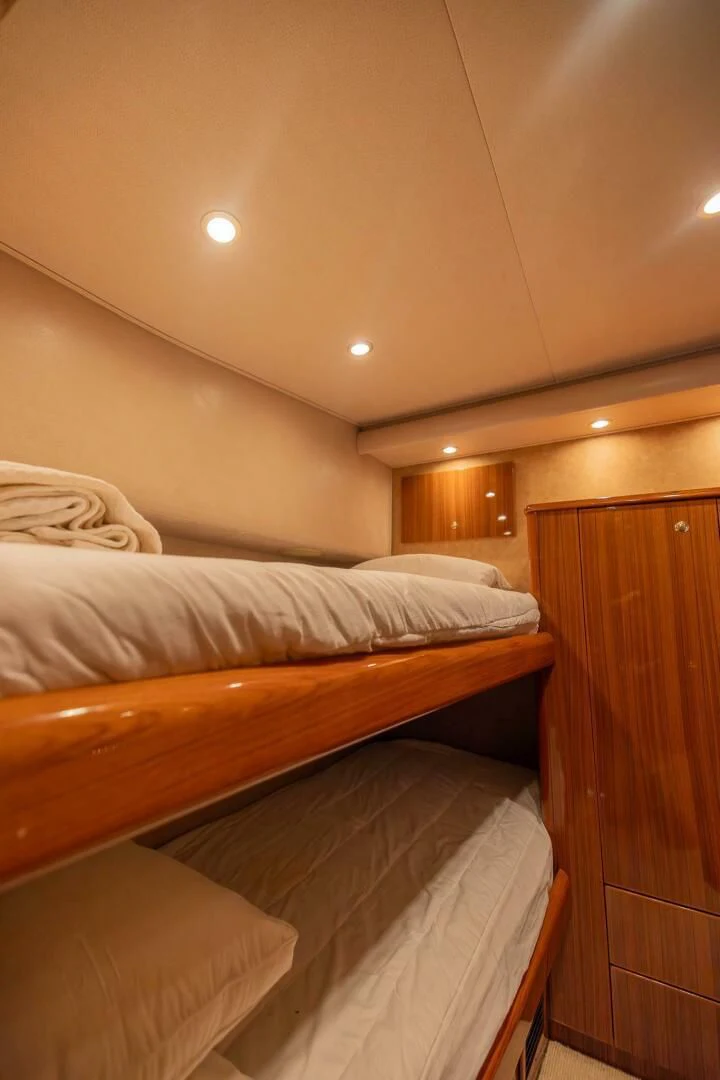a room with a bed and a wood cabinet aboard DON'T STOP BELIEVIN Yacht for Sale