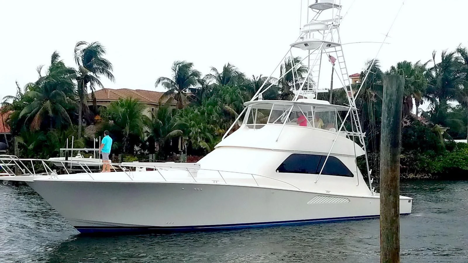 a white boat with a blue stripe aboard DON'T STOP BELIEVIN Yacht for Sale