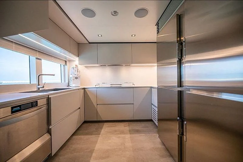 a kitchen with a stainless steel refrigerator aboard SK Yacht for Sale
