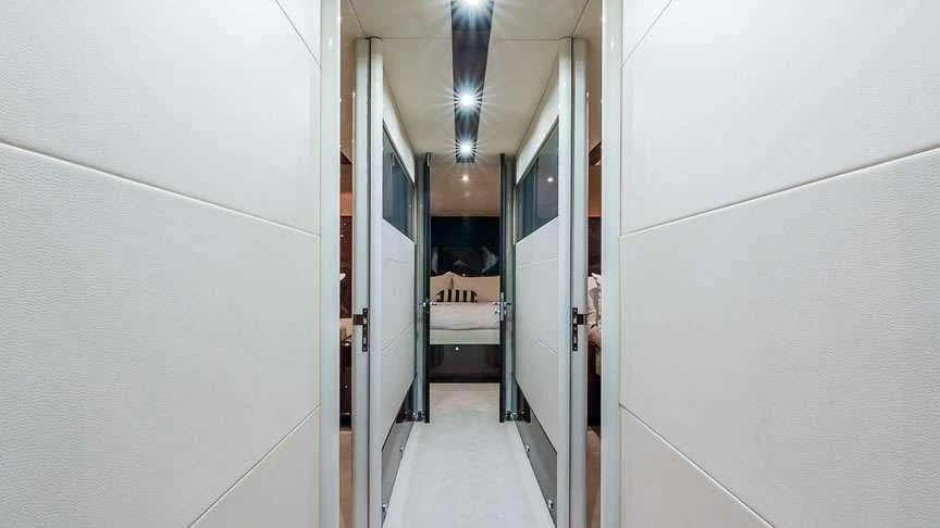 a hallway with a bed and a chair aboard LADY H Yacht for Sale
