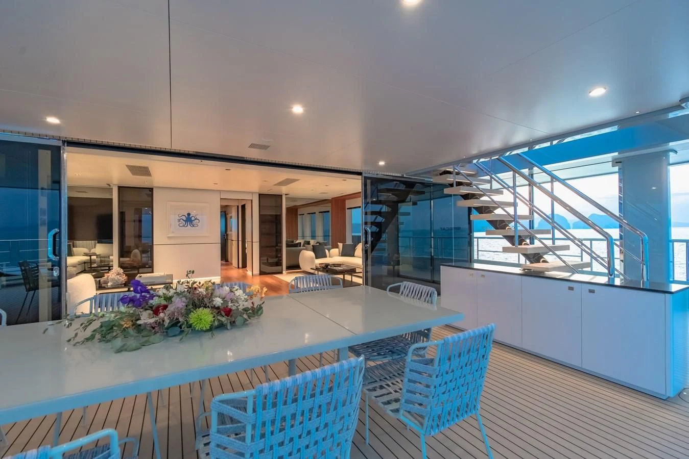 a large open space with a table and chairs and a large glass window aboard SPACECAT Yacht for Sale