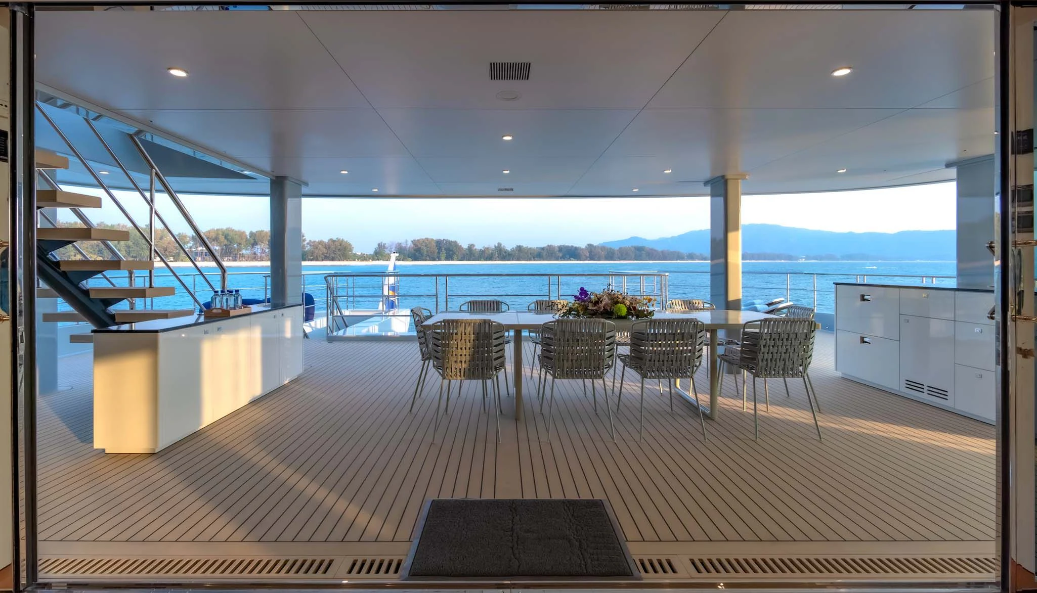 a deck with a table and chairs aboard SPACECAT Yacht for Sale