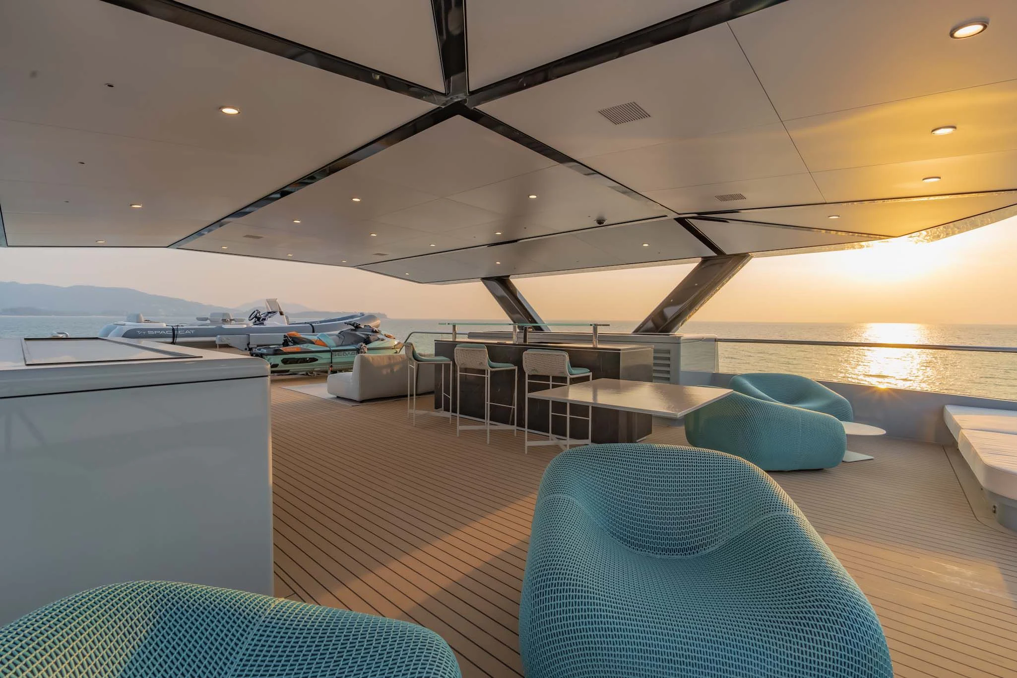 a room with a large bed and a table with chairs aboard SPACECAT Yacht for Sale