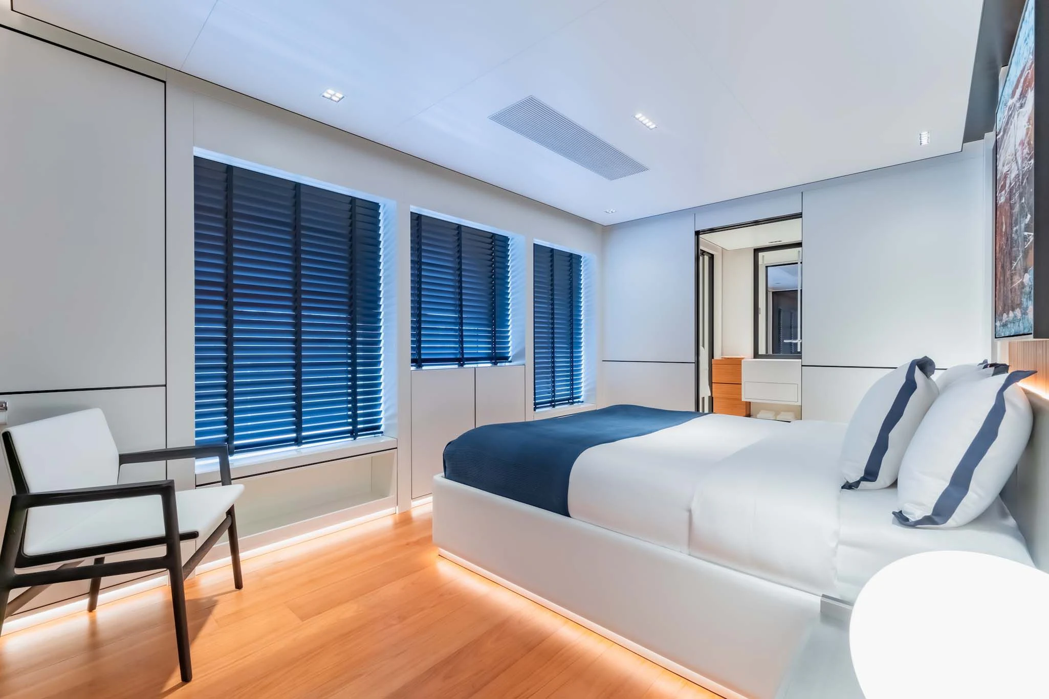 a bedroom with a bed and a chair aboard SPACECAT Yacht for Sale