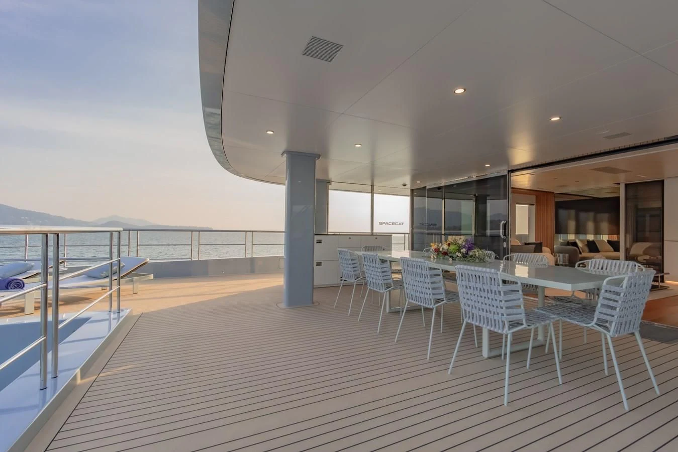 a deck with tables and chairs aboard SPACECAT Yacht for Sale