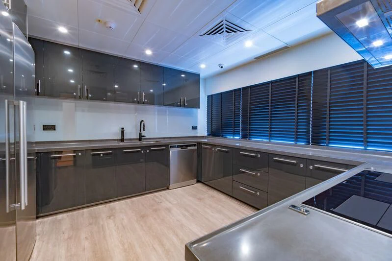 a kitchen with black cabinets aboard SPACECAT Yacht for Sale