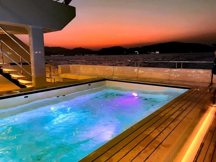 a swimming pool with a bridge in the background aboard SPACECAT Yacht for Sale