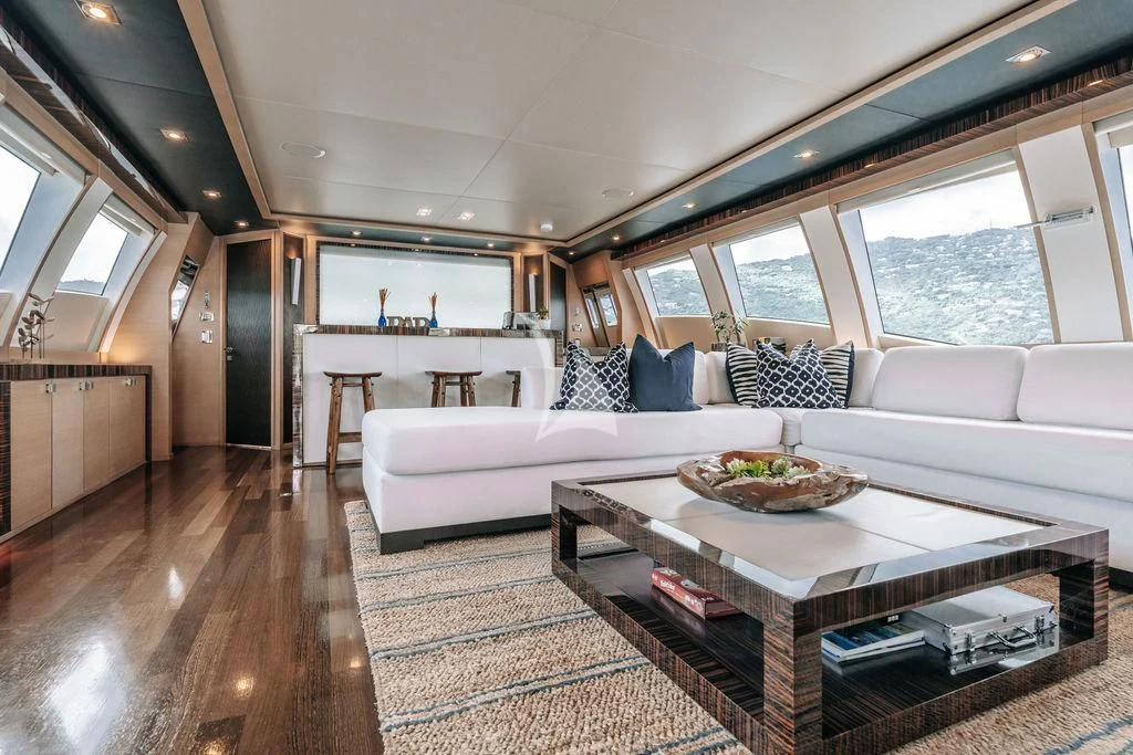 a living room with a large white couch and a large window aboard VANTAGE Yacht for Sale