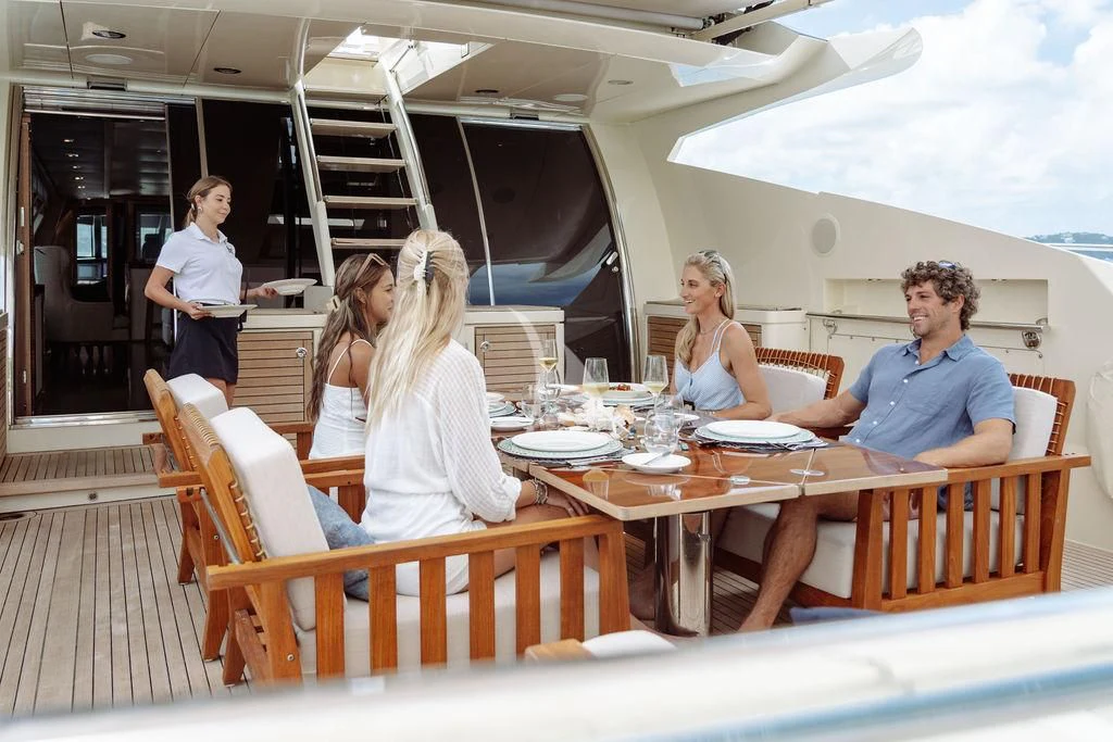 a group of people sitting around a table aboard VANTAGE Yacht for Sale