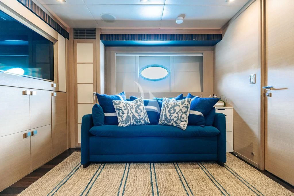 a blue couch in a room aboard VANTAGE Yacht for Sale