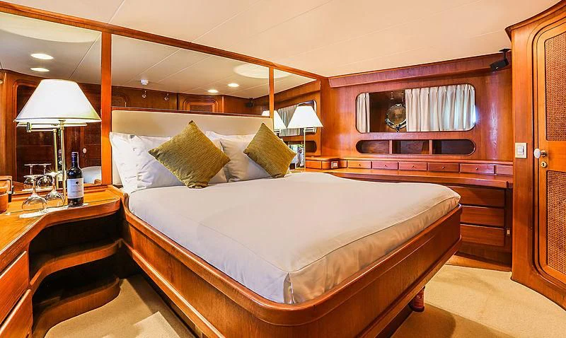a bed with a white sheet and pillows aboard INFINIUM Yacht for Sale