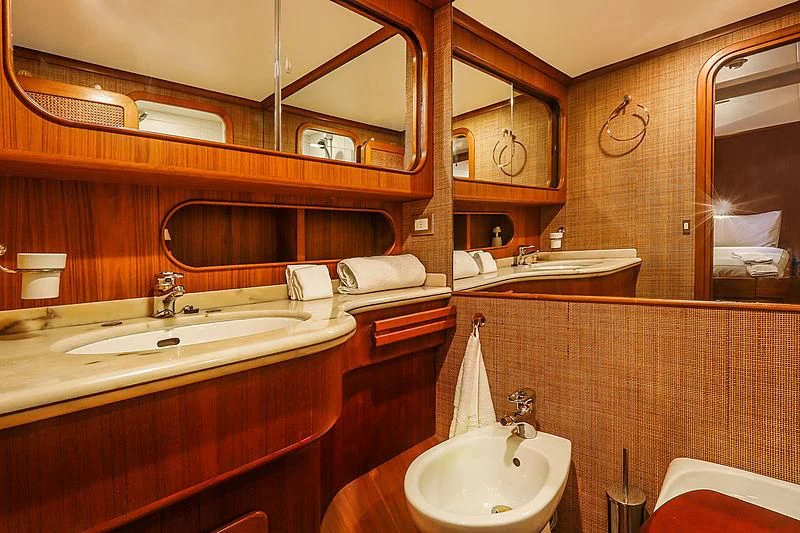 a bathroom with two sinks and mirrors aboard INFINIUM Yacht for Sale