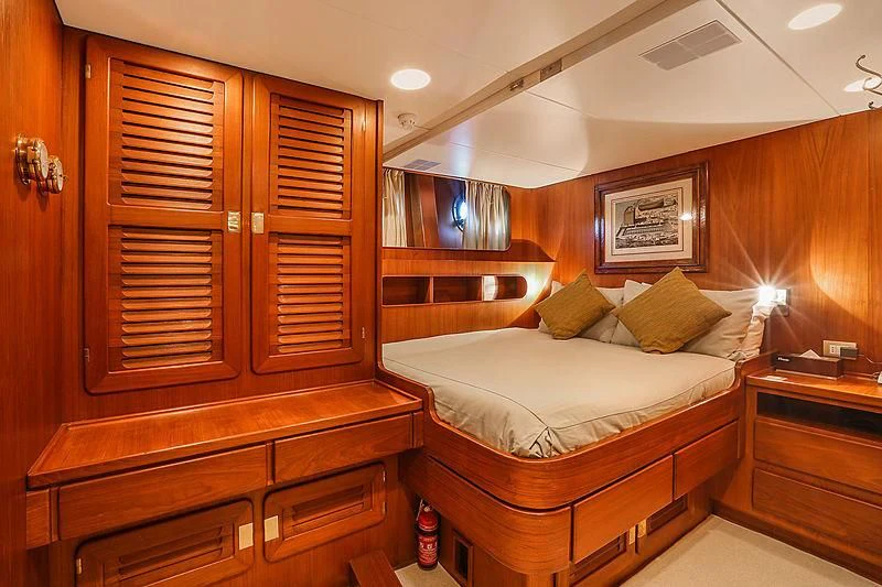 a bedroom with a bed and cabinets aboard INFINIUM Yacht for Sale