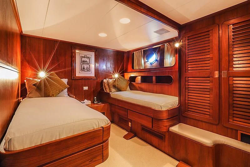 a room with a bed and a wood cabinet aboard INFINIUM Yacht for Sale