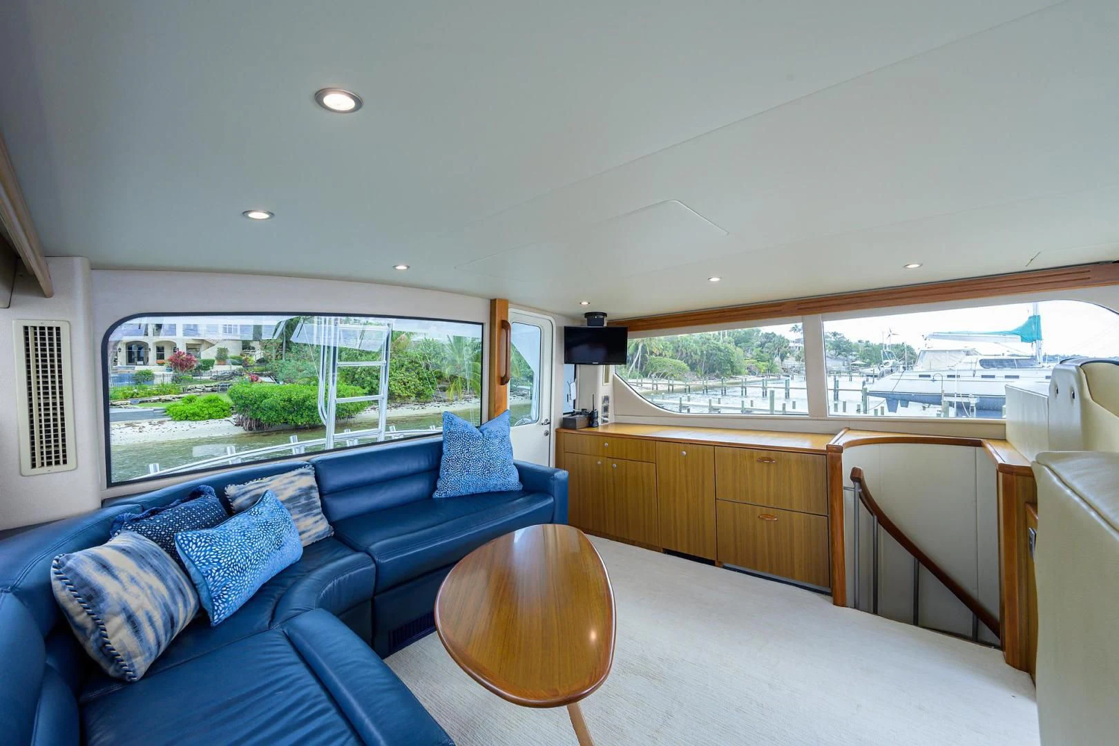 a large living room with a blue couch and a large window aboard RITE ANGLER Yacht for Sale