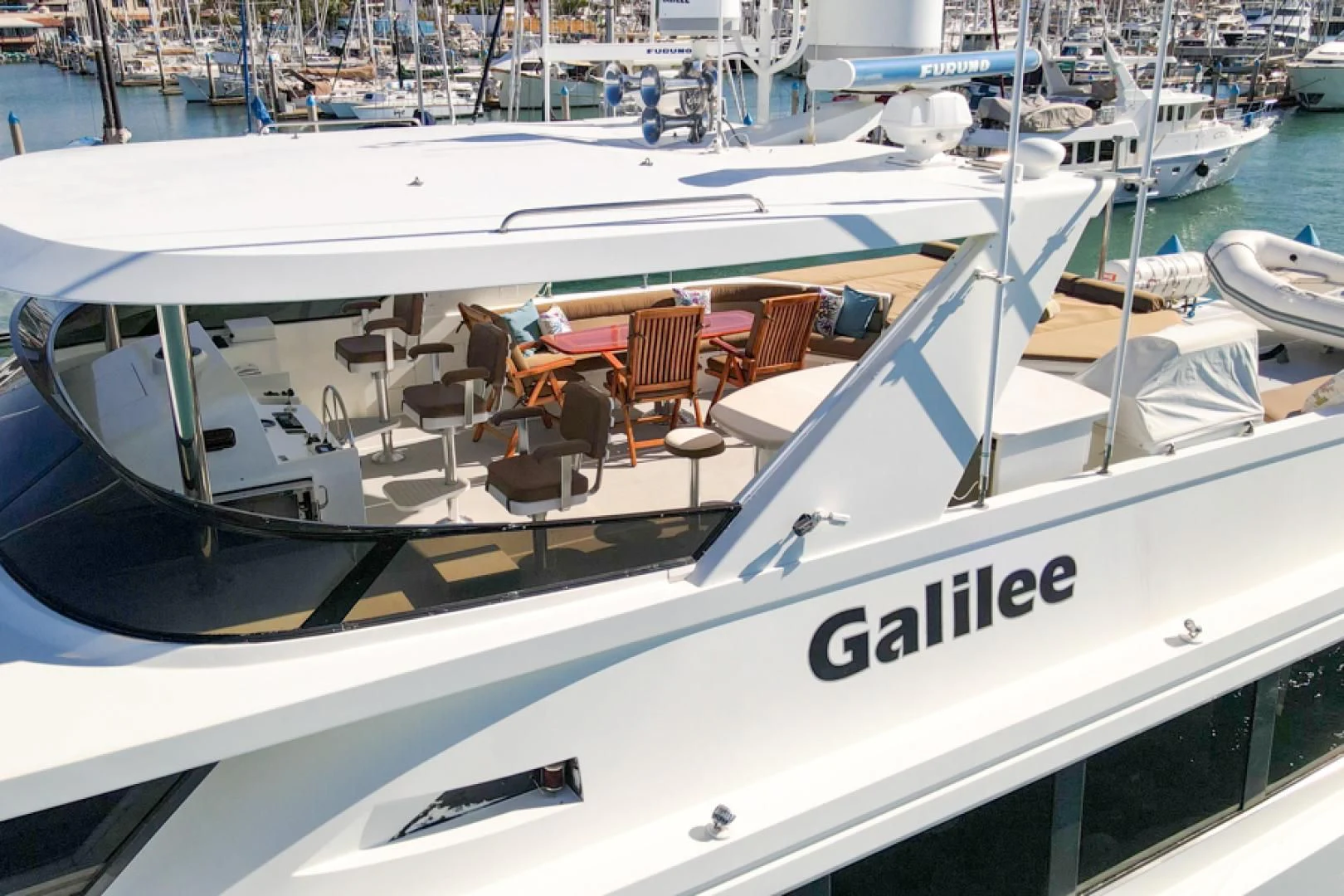 a white boat with chairs on the deck aboard NO EXCEPTIONS Yacht for Sale
