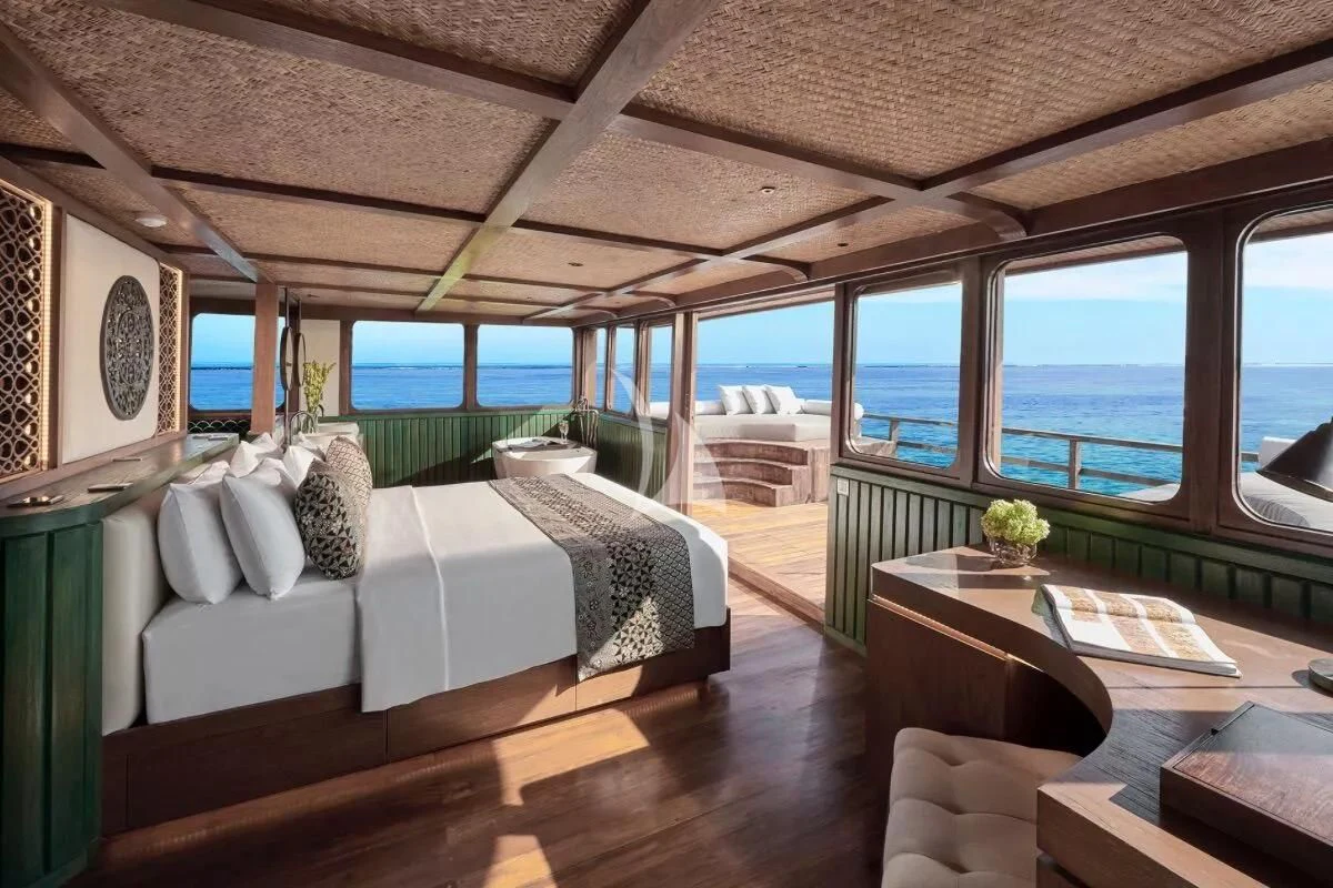 a room with a bed and a table aboard SAMSARA SAMUDRA Yacht for Sale