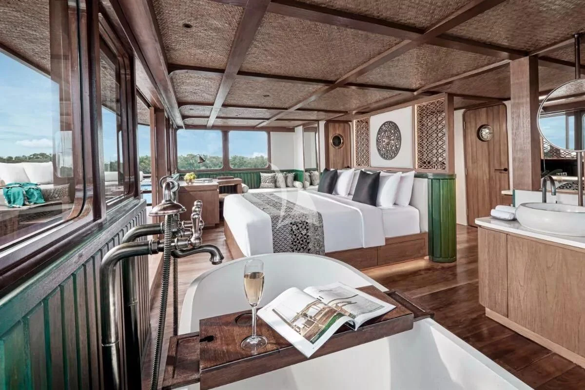 a room with a bed and a table aboard SAMSARA SAMUDRA Yacht for Sale