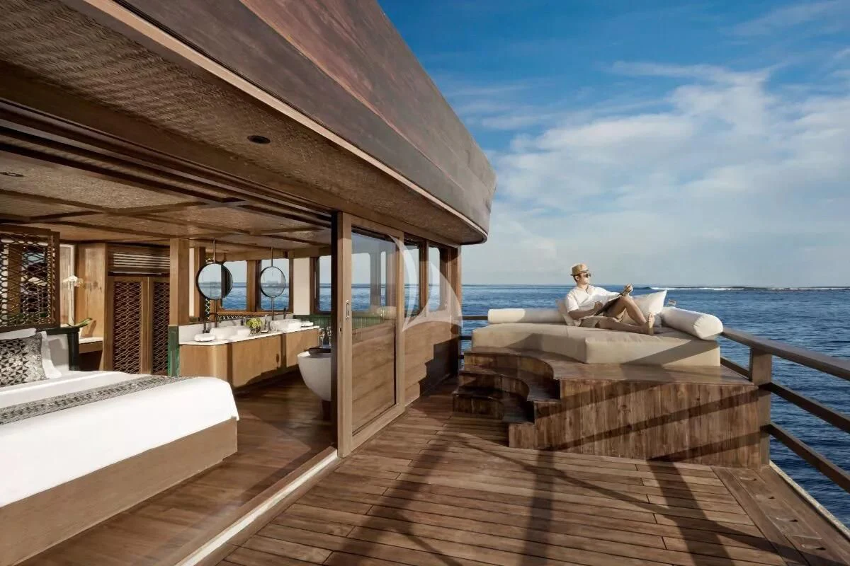 a person sitting on a bed on a boat aboard SAMSARA SAMUDRA Yacht for Sale