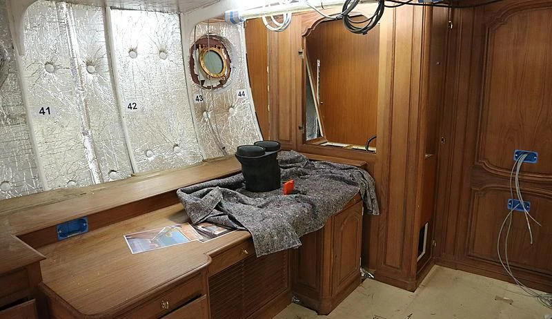 a room with a table and a bed aboard VAGRANT Yacht for Sale