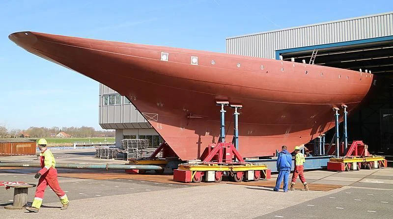 a group of people wearing hardhats and hard hats standing next to a large red machine aboard VAGRANT Yacht for Sale